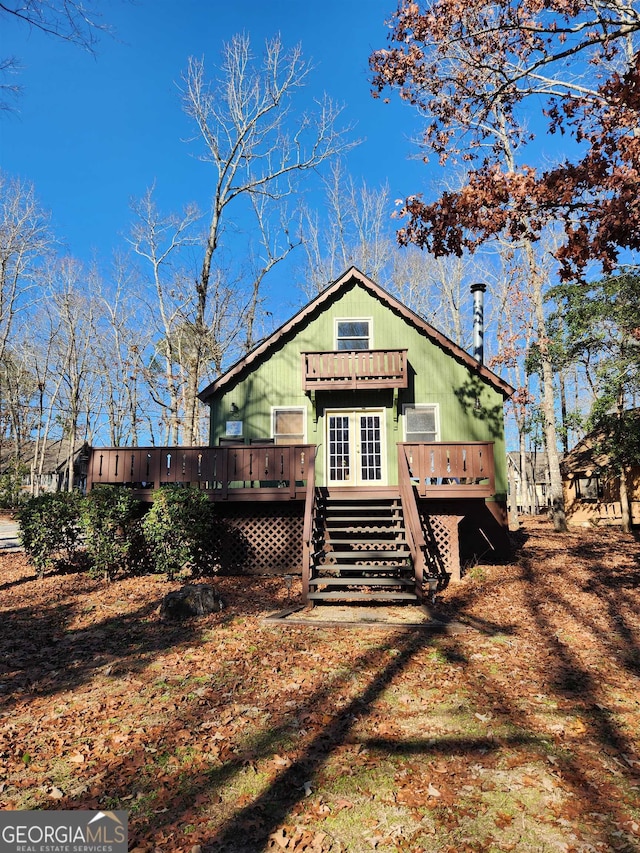 rear view of property with a wooden deck and french doors