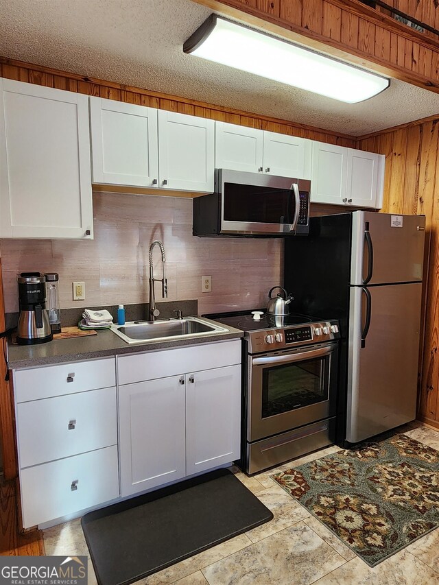 kitchen featuring white cabinets, sink, a textured ceiling, appliances with stainless steel finishes, and decorative backsplash