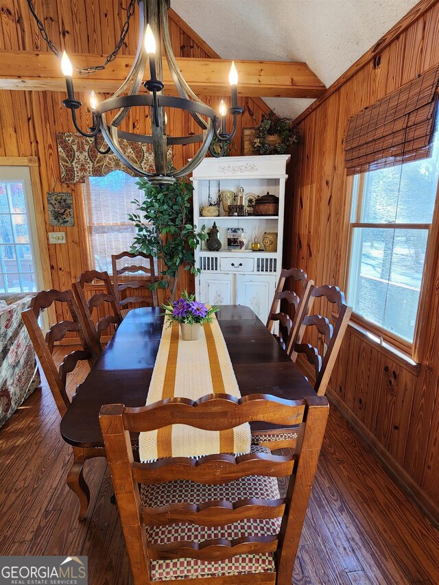 dining space with a textured ceiling, wood walls, dark hardwood / wood-style floors, and a chandelier