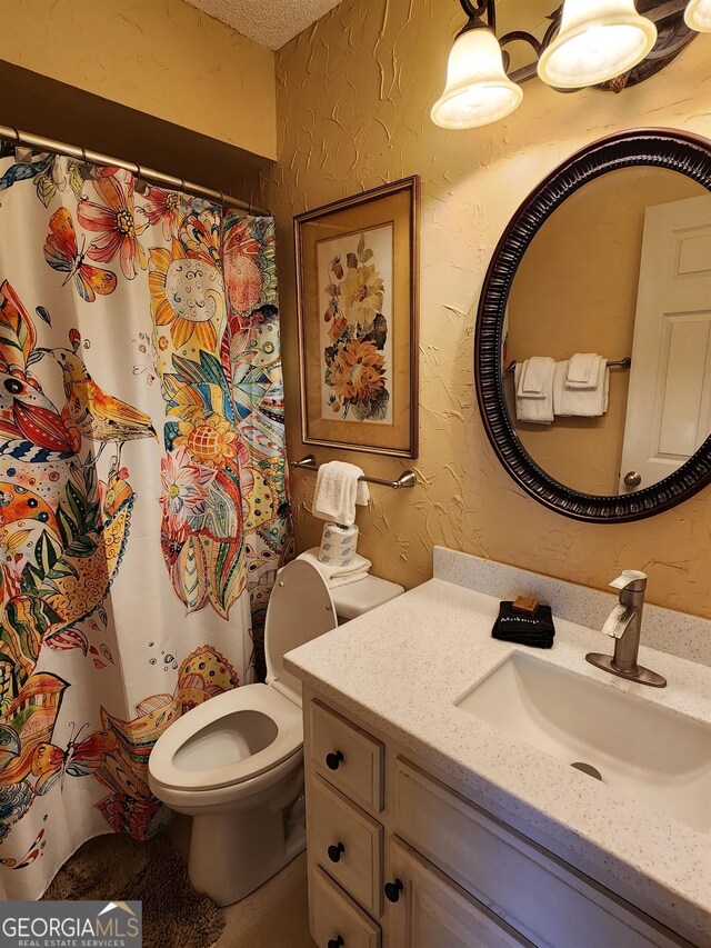 bathroom featuring a textured ceiling, vanity, and toilet