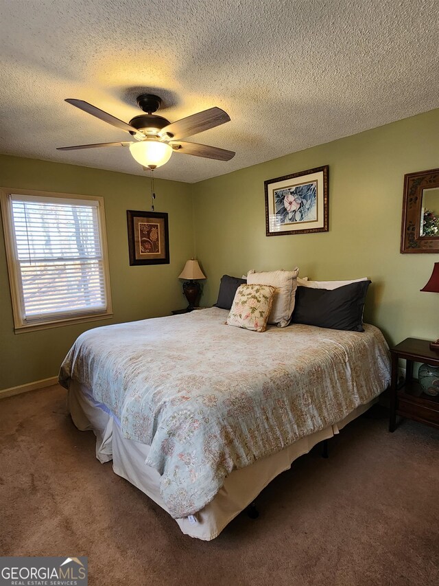 bedroom featuring ceiling fan, carpet floors, and a textured ceiling