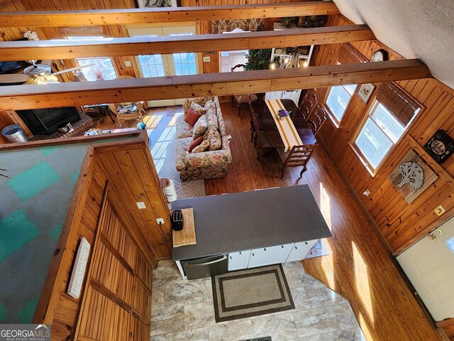 interior space with ceiling fan, wood walls, and vaulted ceiling