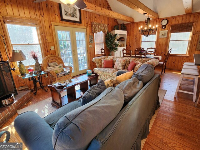 living room featuring french doors, wooden walls, and wood-type flooring