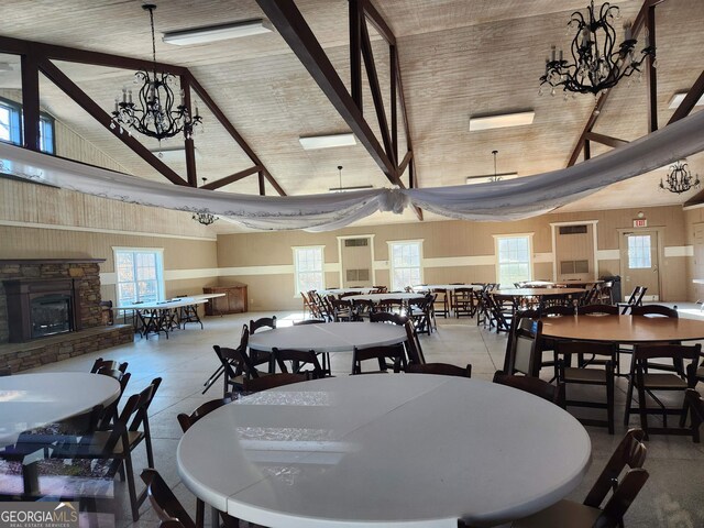 dining space with a fireplace, high vaulted ceiling, and a notable chandelier