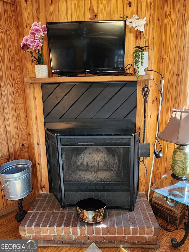 room details featuring hardwood / wood-style flooring, a fireplace, and wood walls