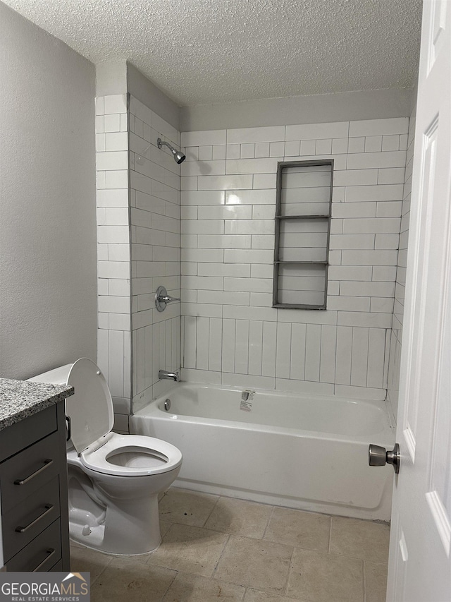 full bathroom with vanity, tiled shower / bath, a textured ceiling, and toilet