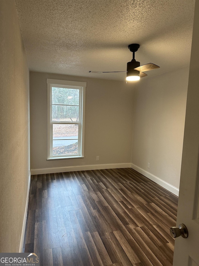 spare room featuring ceiling fan, dark hardwood / wood-style flooring, and a textured ceiling