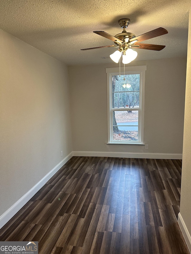 empty room featuring ceiling fan, a textured ceiling, and dark hardwood / wood-style flooring