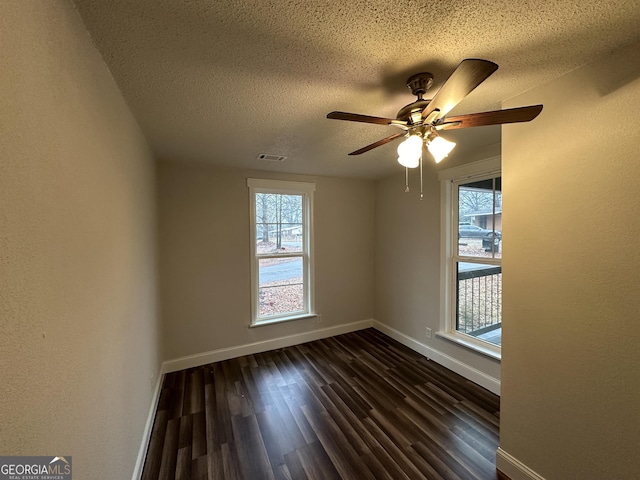 spare room with ceiling fan, dark hardwood / wood-style floors, and a textured ceiling