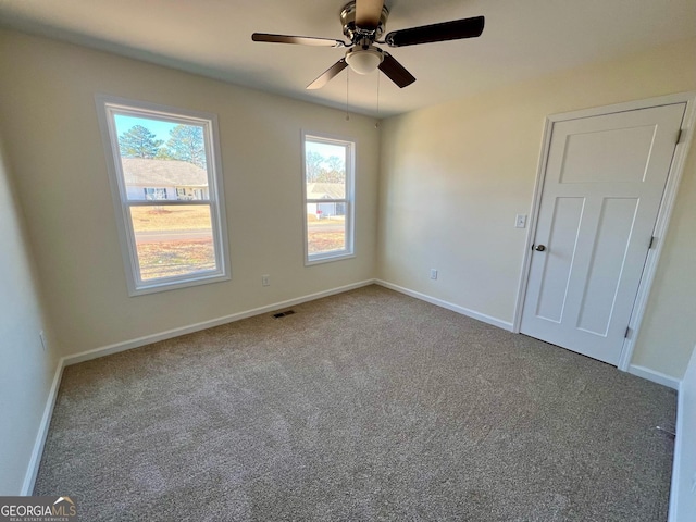 carpeted empty room featuring ceiling fan