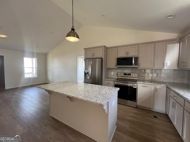 kitchen with appliances with stainless steel finishes, pendant lighting, decorative backsplash, light stone counters, and dark wood-type flooring