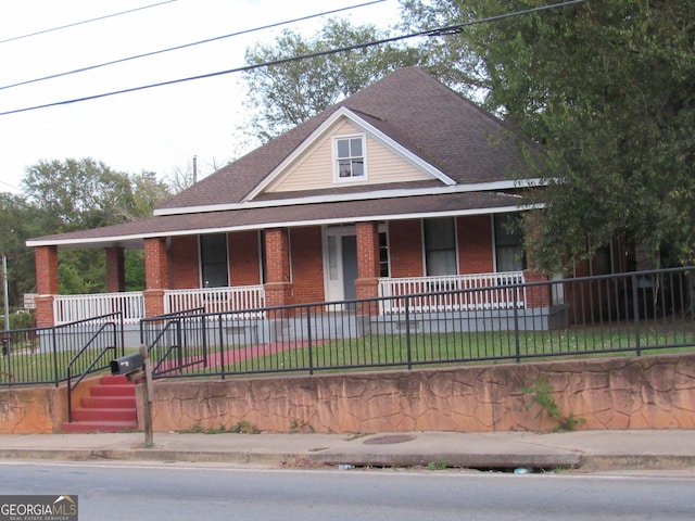4154 Houston Ave, Macon, GA 31206 - farmhouse inspired home with covered porch, fence, a shingled roof, and brick siding