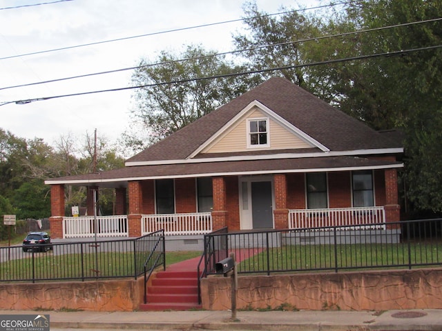 4154 Houston Ave, Macon, GA 31206 - farmhouse with brick siding, fence, a shingled roof, a front yard, and a porch