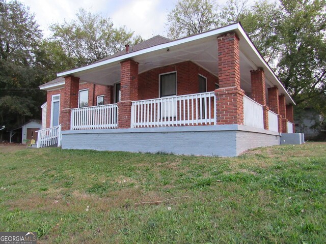 4154 Houston Ave, Macon, GA 31206 - view of front of house featuring a front lawn, brick siding, and a porch