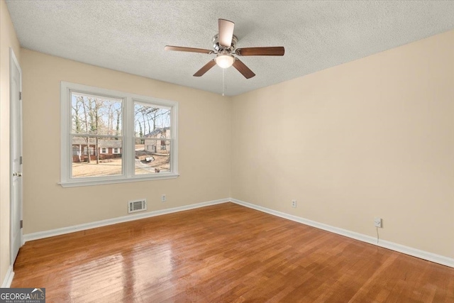 unfurnished room featuring light hardwood / wood-style floors, ceiling fan, and a textured ceiling