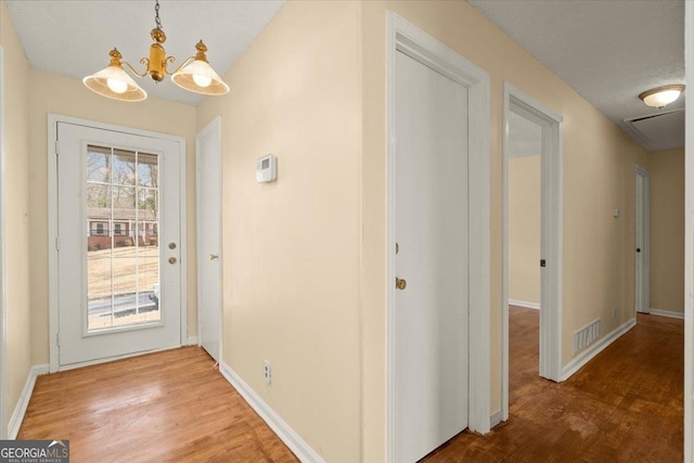 foyer entrance with a chandelier and hardwood / wood-style flooring