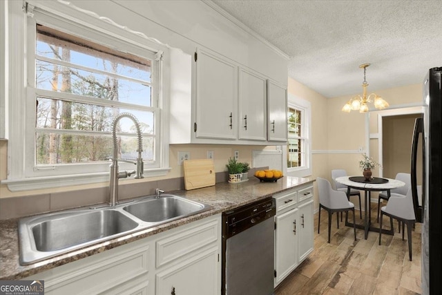 kitchen featuring black refrigerator, decorative light fixtures, white cabinets, a chandelier, and dishwasher