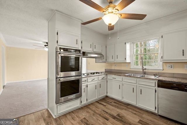 kitchen with ceiling fan, sink, appliances with stainless steel finishes, wood-type flooring, and white cabinetry