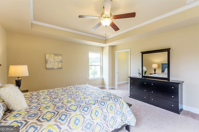 carpeted bedroom with ornamental molding, a closet, ceiling fan, and a tray ceiling