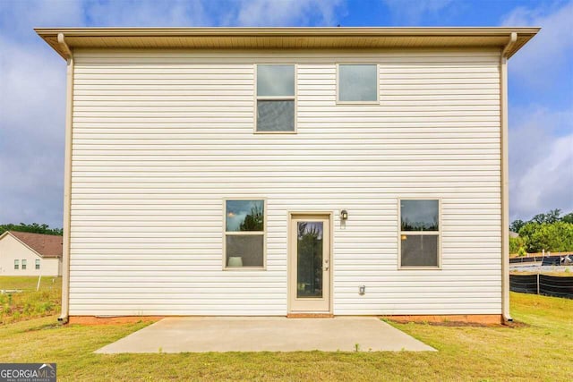 rear view of property featuring a lawn and a patio