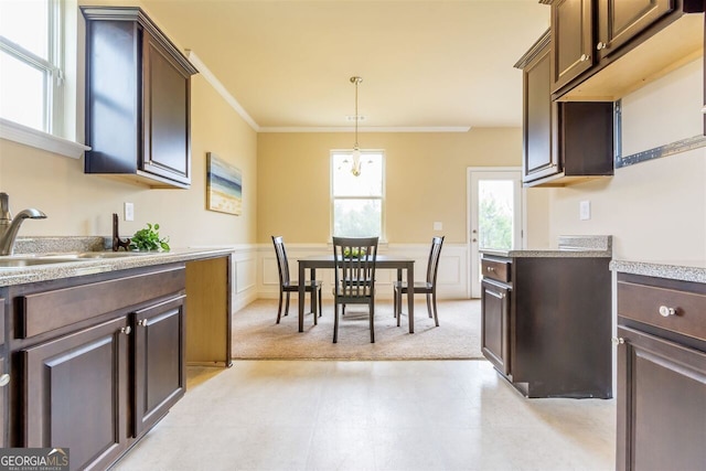 kitchen featuring light tile flooring, hanging light fixtures, and dark brown cabinets