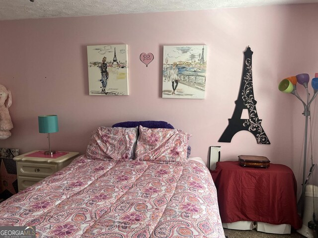 bedroom with carpet and a textured ceiling