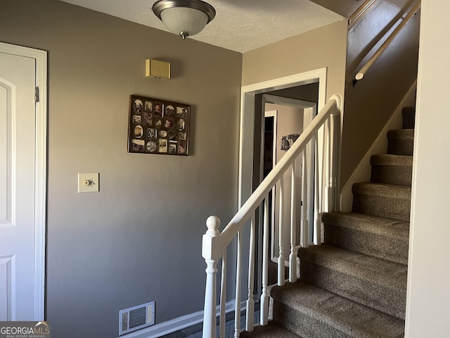 stairs with a textured ceiling