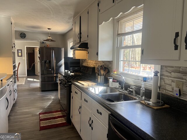 kitchen with tasteful backsplash, black appliances, white cabinets, wall chimney range hood, and dark hardwood / wood-style floors