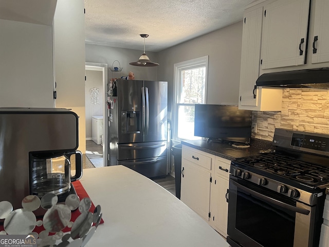 kitchen with a textured ceiling, appliances with stainless steel finishes, pendant lighting, decorative backsplash, and white cabinets