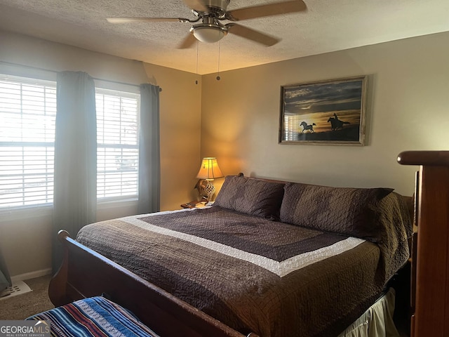 bedroom with a textured ceiling, multiple windows, carpet, and ceiling fan