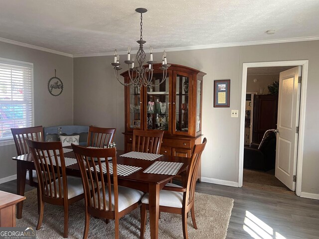 dining area with a chandelier, crown molding, and wood-type flooring