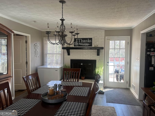 dining area with ornamental molding, a textured ceiling, and hardwood / wood-style flooring