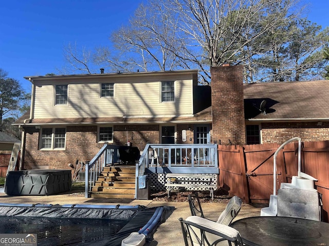 rear view of property featuring a patio and a deck