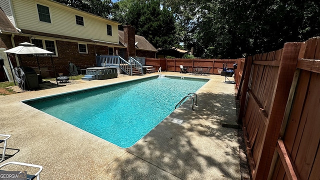 view of swimming pool with a patio area and an outdoor fire pit