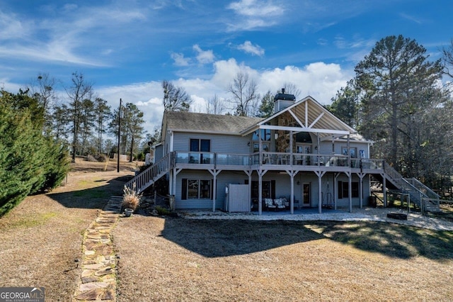 back of property with a deck and a patio area