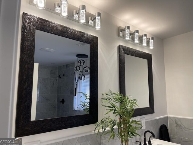 bathroom with a tile shower and sink