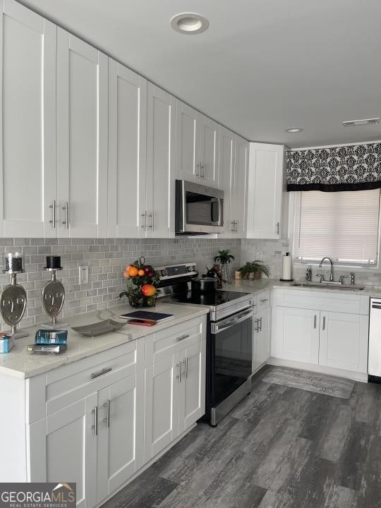 kitchen featuring white cabinets, dark wood-type flooring, electric range oven, and sink