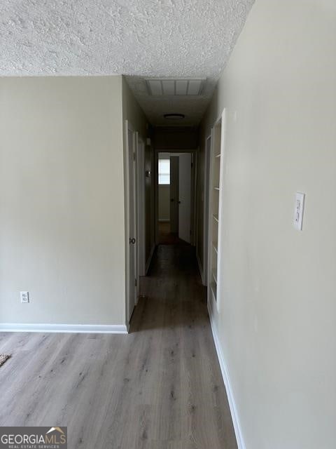 corridor featuring dark wood-type flooring and a textured ceiling