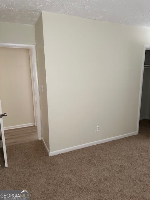 carpeted spare room featuring a textured ceiling