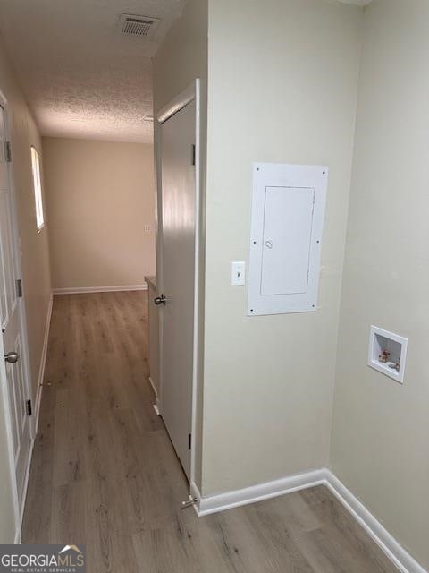 corridor featuring light hardwood / wood-style floors and a textured ceiling