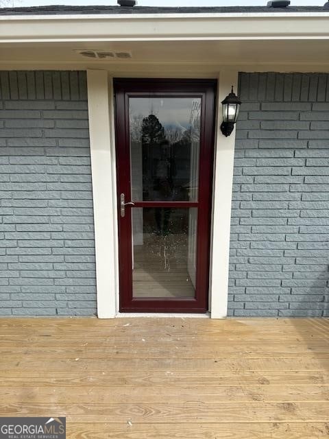 view of exterior entry with a deck