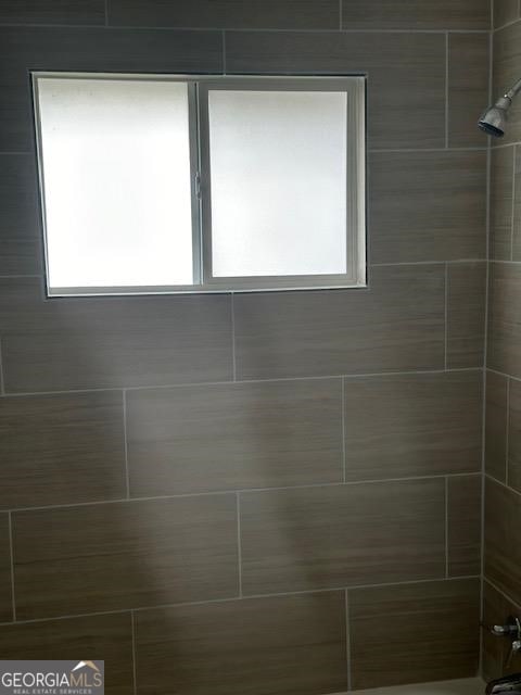 bathroom featuring tiled shower / bath