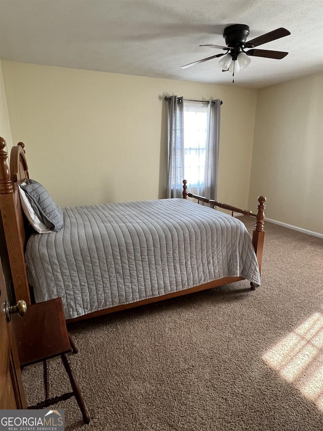 carpeted bedroom featuring a textured ceiling and ceiling fan