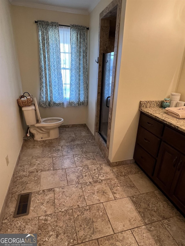 bathroom with ornamental molding, toilet, vanity, and walk in shower