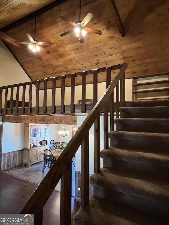 stairs with ceiling fan with notable chandelier, high vaulted ceiling, hardwood / wood-style flooring, wooden ceiling, and beam ceiling