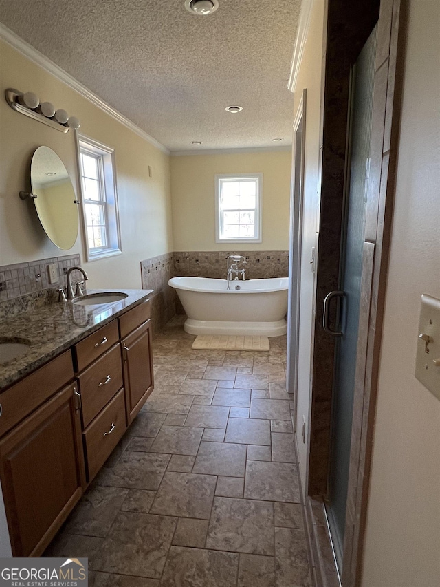 bathroom with vanity, crown molding, a textured ceiling, and plus walk in shower