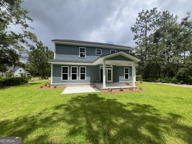 back of house featuring a lawn and a patio