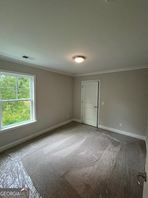 carpeted empty room with crown molding