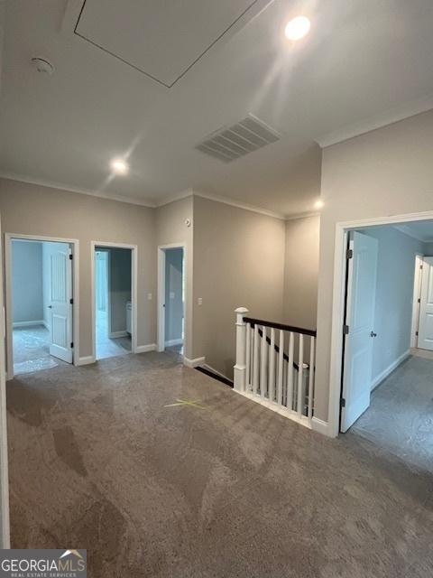 carpeted spare room featuring crown molding