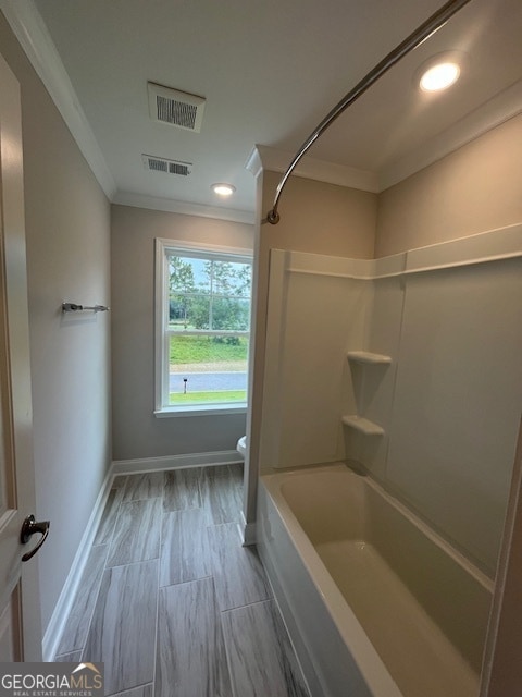 bathroom with crown molding, toilet, bathtub / shower combination, and hardwood / wood-style flooring